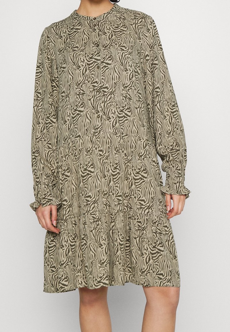 Abito a maniche lunghe con stampa zebrina beige e verde oliva, caratterizzato da un collo rotondo, dettagli con bottoni e una gonna a strati.