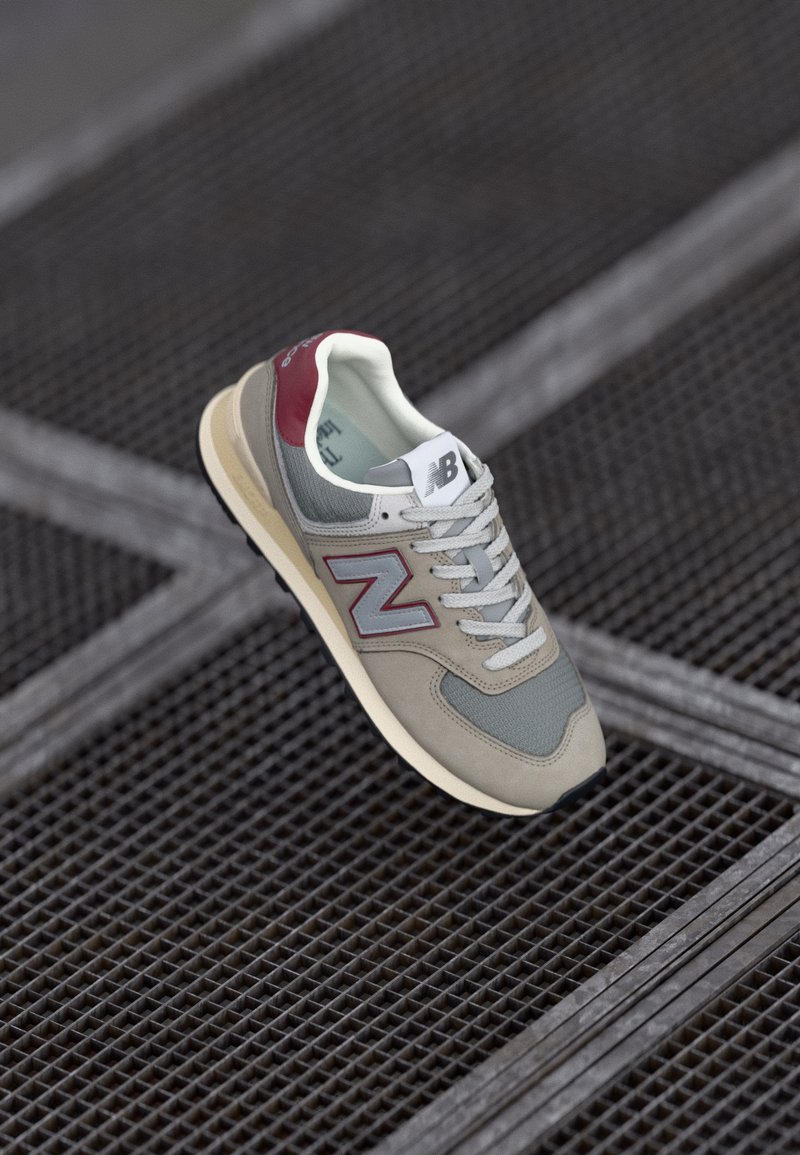 Sneaker in rete grigio e suede con accenti bordeaux, suola in gomma e lacci bianchi. Presenta un grande logo 'N' sul lato.