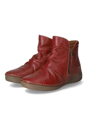 Paire de bottines en cuir rouge avec des fermetures éclair latérales et des semelles en caoutchouc marron, dotées d'une texture douce et plissée ainsi que de détails cousus.