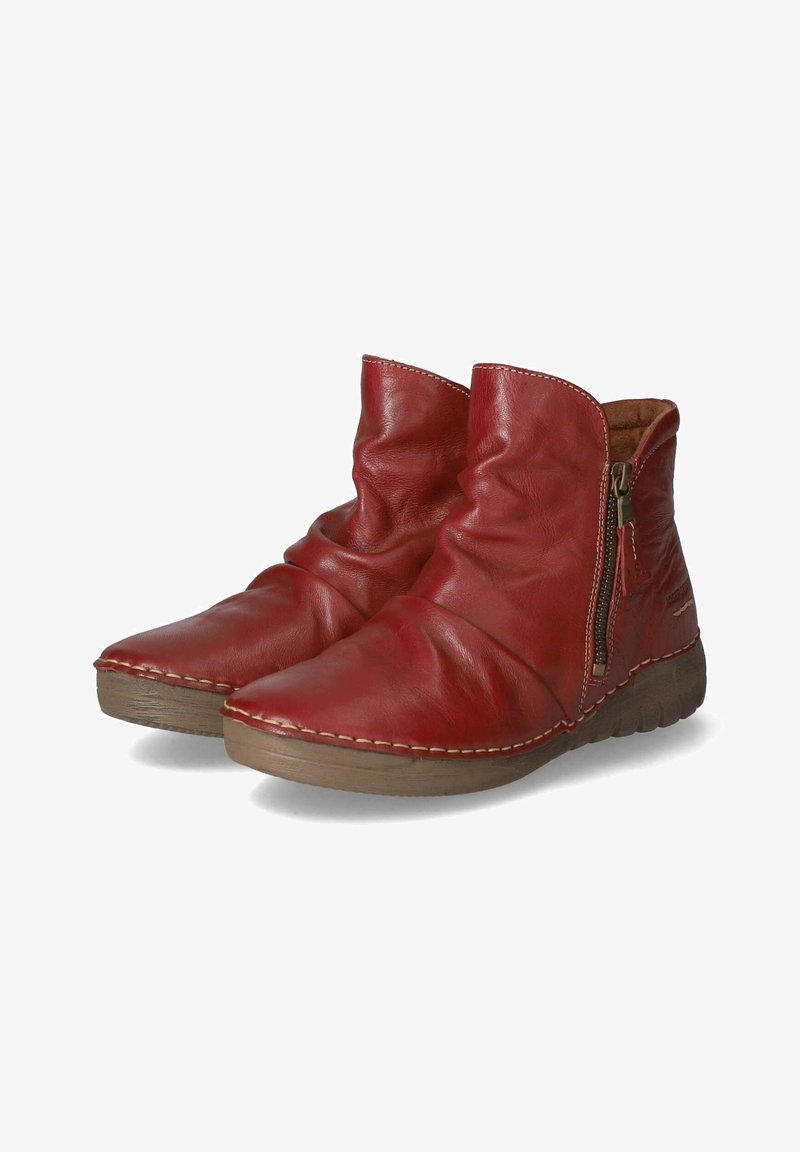 Paire de bottines en cuir rouge avec des fermetures éclair latérales et des semelles en caoutchouc marron, dotées d'une texture douce et plissée ainsi que de détails cousus.