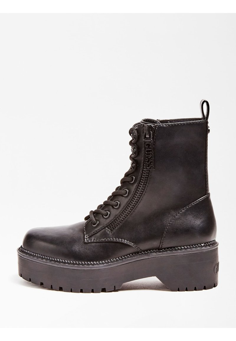 Bottine en cuir noir à lacets avec fermeture éclair latérale, semelle épaisse crantée et languette au talon.