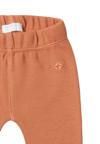 Geribde terracotta leggings met een elastische tailleband, voorzien van een klein kruissteekdetail aan de zijkant. Zachte textuur en aansluitend ontwerp.
