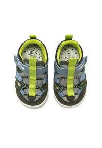 Zapatos infantiles que combinan malla gris y acentos verdes, con una correa segura y una suela flexible. Destacan por su diseño transpirable.
