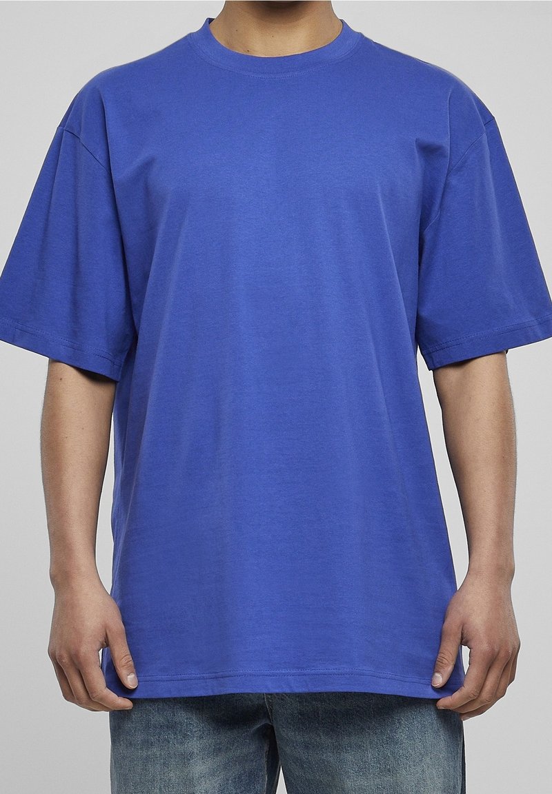 Niebieska bawełniana koszulka z okrągłym dekoltem, krótkimi rękawami i luźnym krojem. Gładka tekstura w jednolitym kolorze, bez wzorów czy akcentów.