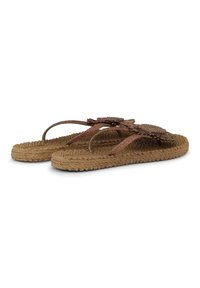 Chanclas marrones tejidas con suelas trenzadas y adornos decorativos en forma de girasol en las tiras, sobre un fondo blanco.