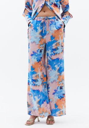 Luftige weit geschnittene Hosen im Batikmuster in Blau, Orange und zartem Pink. Weicher Stoff mit einem elastischen Bund und seitlichen Taschen.