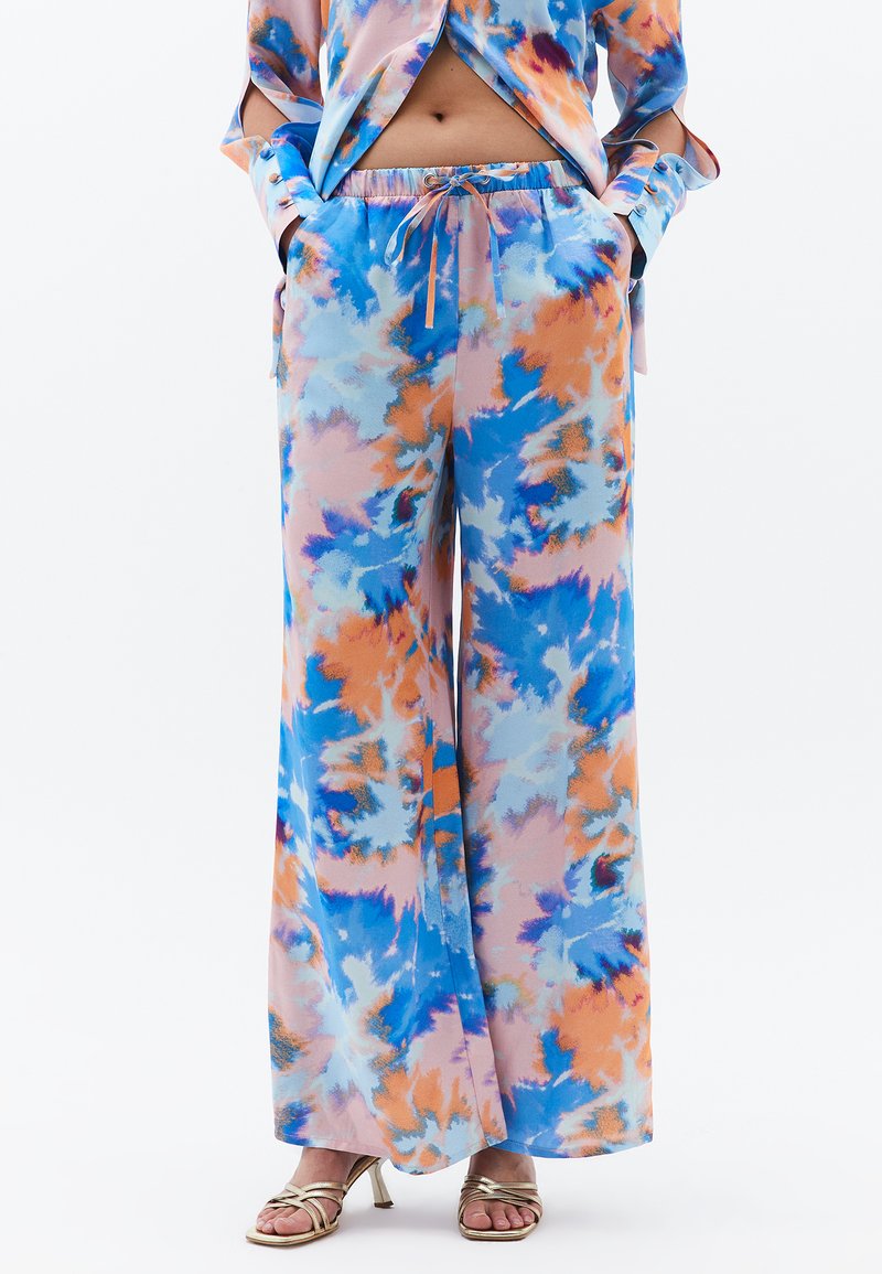 Pantalons fluides à jambes larges avec un motif tie-dye bleu, orange et rose doux. Tissu doux avec une taille élastique et des poches latérales.
