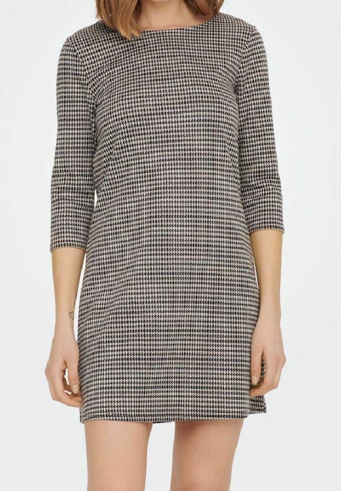 Femme portant une robe ajustée à motif pied-de-poule avec des manches trois-quarts et un col rond, debout sur un fond blanc uni.