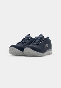 Navy athletic shoes with a textured upper, gray rubber sole, and lace-up design. Features a prominent logo on the side and pull tab on the heel.