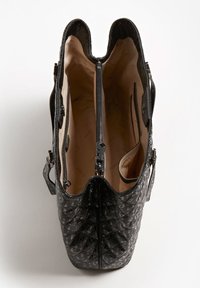 Sort læderhåndtaske med et struktureret mønster, opdelt indre og et centralt lynlåslukket rum. Indersiden er foret med glat beige stof.