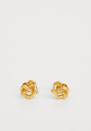Gold metal stud earrings featuring a textured intertwined knot design with a small gem accent, exhibiting a polished and shiny finish.