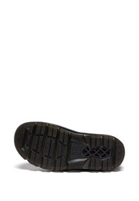 Semelle de chaussure en caoutchouc noir avec des crampons profonds, des motifs de grip texturés et un logo rectangulaire embossé près du centre.