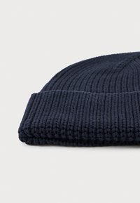 Gorro de malha azul-marinho com textura canelada e aba dobrada, feito de um tecido macio e elástico para conforto e calor.