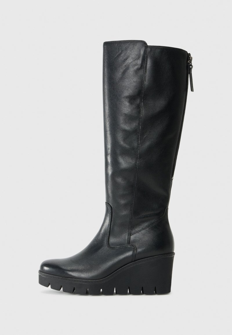 Bottes noires hautes jusqu'au genou en cuir lisse. Elles possèdent une semelle compensée avec un bord texturé et une fermeture éclair latérale.
