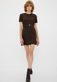 Korte bruine jurk met een getailleerde silhouet, korte mouwen, gouden knoopdetails op de schouder en een bijpassende riem in de taille.