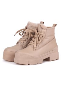 Botas de tobillo de cuero beige con forro de piel sintética, puntera redondeada y suela de goma plana y gruesa. Presenta cordones redondos y una tira en el talón.