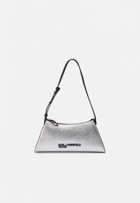 Sidabrinės metalizuotos peties rankinė su elegantišku trikampiu dizainu, juoda dirželiu ir logotipo detalėmis priekyje. Lygi tekstūra ir kompaktiška forma.