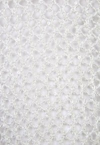 Biała koronka z finezyjnym wzorem diamentu, o delikatnej, lekko błyszczącej fakturze, stworzonej przez metaliczne nitki.