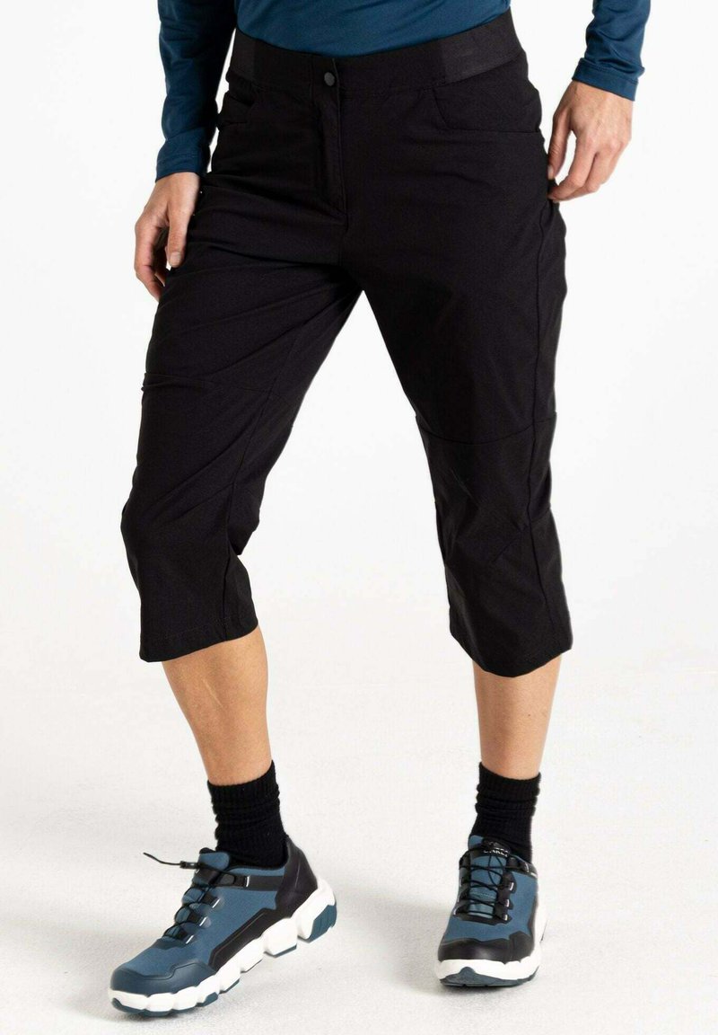 Schwarze, kurze Hosen aus glattem Stoff, mit Knopfverschluss, seitlichen Taschen und geradem Bein. Getragen mit dunklen Sportschuhen.