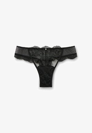 Sort blonde trusse med blomsterdesign, gennemsigtig mesh-sider og en lille dekorativ knap foran. Blød tekstur og minimal dækning.