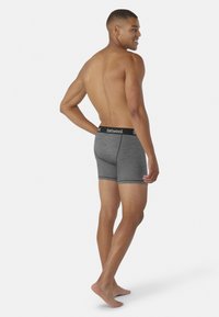 Boxer in misto lana grigio con vita nera riportante il logo. Il tessuto appare morbido; il design è aderente e lungo fino a metà coscia.
