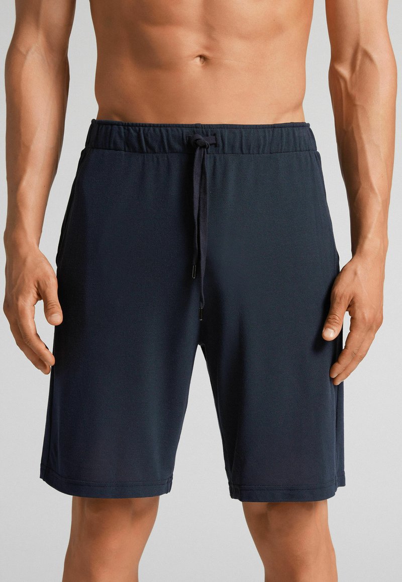 Pantalones cortos azul marino hechos de una tela ligera, con una cintura elástica y cordón, bolsillos laterales y una textura suave.