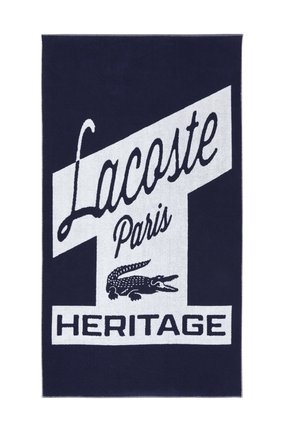 Tissu bleu foncé avec le texte blanc "Lacoste Paris Heritage" et un logo crocodile blanc en dessous du nom de la marque.