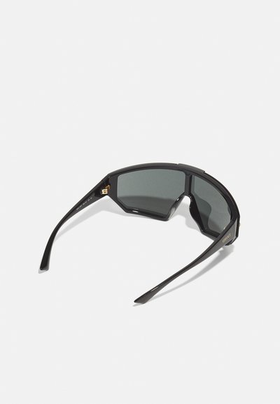 Black sunglasses with an angular frame and dark lenses. Features gold hardware accents and tapered arms. Smooth texture throughout.