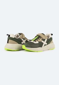 Zapatillas deportivas verdes y beiges con detalles de malla, un acabado texturizado, acentos neón en la suela y un diseño de cordones seguro.