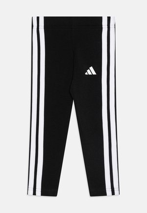 Leggings sportivi neri con tre strisce verticali bianche su entrambi i lati e un piccolo logo Adidas bianco sulla coscia sinistra.