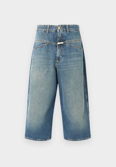 Culottes en denim bleu clair à coupe décontractée, avec cinq poches et une fermeture à bouton. Des détails usés près des coutures ajoutent de la texture.