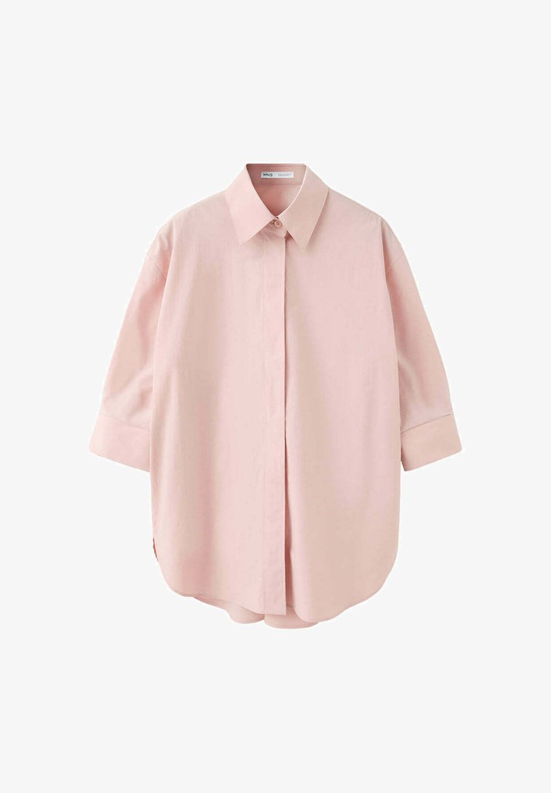 Chemise oversize rose clair avec boutons, manches trois-quarts et col pointu, présentée sur fond blanc.