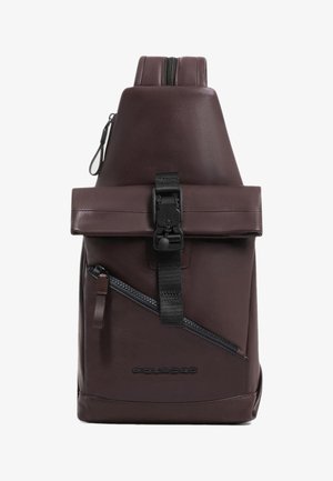 Bruine leren rugzak met een roll-top sluiting, een voorvak met ritssluiting en verstelbare riem. Heeft een gestructureerde afwerking en een logodetail.