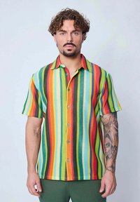 Chemise à manches courtes multicolore avec des boutons, présentant des rayures verticales dans des teintes vives de rouge, vert, bleu, orange et jaune, avec des boutons turquoise.