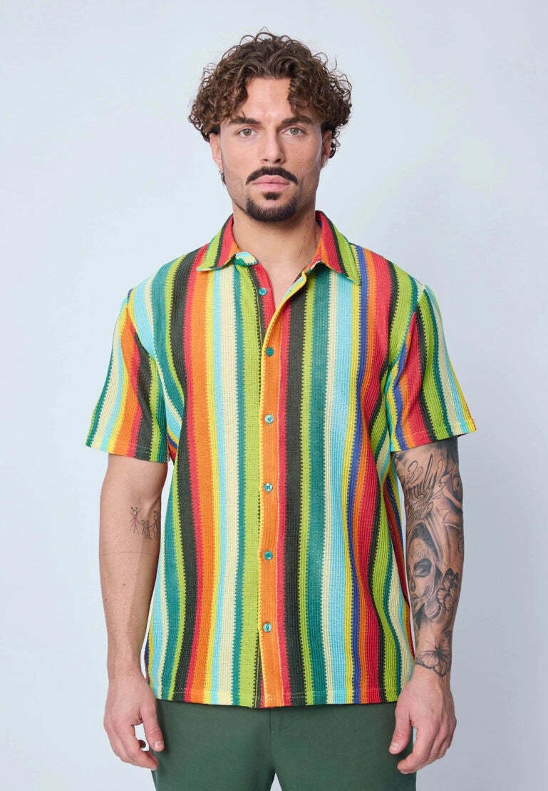 Chemise à manches courtes multicolore avec des boutons, présentant des rayures verticales dans des teintes vives de rouge, vert, bleu, orange et jaune, avec des boutons turquoise.