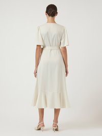 Λευκό φόρεμα με μήκος μέχρι το γόνατο, κοντά φουσκωτά μανίκια και φαρδύ στρίφωμα. Κατασκευασμένο από λείο ύφασμα, διαθέτει ζώνη στη μέση. Απλός και κομψός σχεδιασμός.
