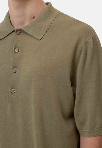 Polo shirt verde oliva realizzato in tessuto morbido, con colletto classico, pettorina a tre bottoni e maniche corte con una vestibilità rilassata.