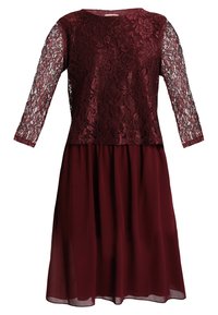Burgundiklänning med spetsöverdel och trekvartslånga ärmar. Flödande chiffongkjol skapar en lager-på-lager-effekt. Slät textur genom hela klänningen.