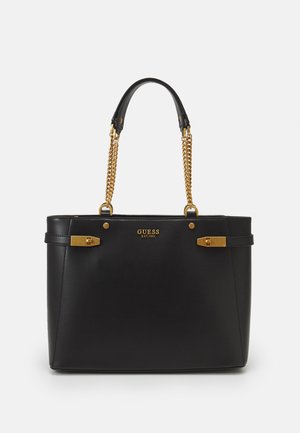 Sort Guess håndtaske med guldkædehåndtag, gulddetaljer og mærkesnavnet "Guess Est 1981" på frontens midte.