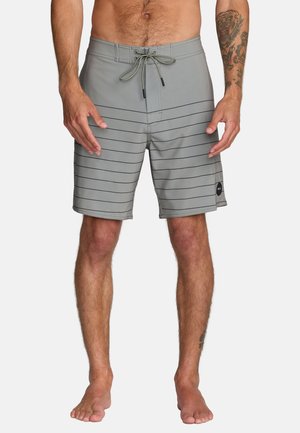 Szare kąpielówki z czarnymi poziomymi paskami, elastyczną talią i sznurkiem. Wykonane z lekkiego materiału z bocznymi kieszeniami.