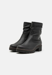 Bocanci negri din piele, cu un design lejer, vârful rotund și tocul bloc robust, accentuați de o talpă texturată pentru aderență.