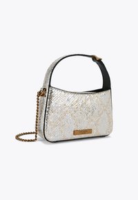 Borsa a tracolla con motivo di pelle di serpente nei toni bianco e oro, caratterizzata da un bordo nero, una tracolla a catena e una placca in metallo con logo sulla parte anteriore.