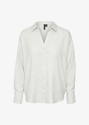 Gaiši pelēks iekniebts krekls ar mīkstu, teksturētu audumu, V veida kakla izgriezumu un garām piedurknēm. Iezīmē noapaļotu apakšējo malu un vienkāršas baltas pogas.