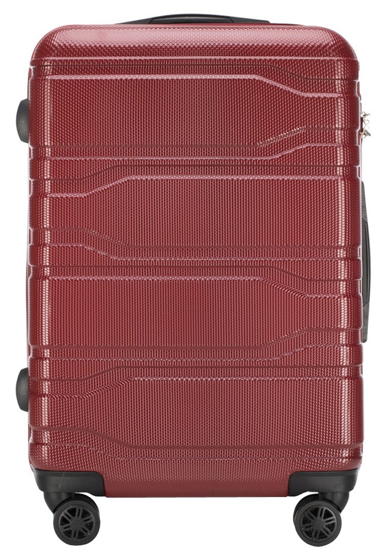 Valise rigide rouge avec surface texturée, design rainuré, poignée supérieure et quatre roues pivotantes pour la mobilité. Conçue pour la durabilité.