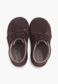 Zapatos de ante marrón con punteras redondeadas, que cuentan con cordones elásticos, un forro suave y una etiqueta de la marca de colores en el interior.