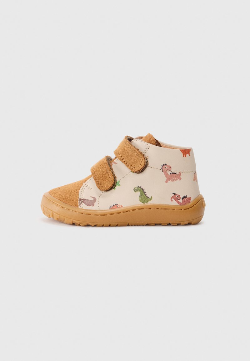 Chaussures pour tout-petits avec une tige en cuir beige ornée de motifs de dinosaure, des accents en daim marron, deux bandes Velcro et une semelle en caoutchouc.