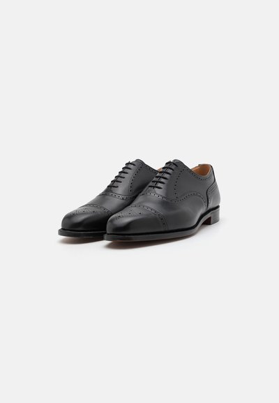 Scarpe eleganti in pelle nera con finitura liscia, design con punta chiusa, dettagli decorativi in brogue e suola in legno. Stilizzate con allacciatura classica.