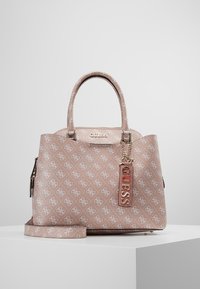 Torba w kolorze różowego rumieńca z wytłoczonym wzorem logo, o uporządkowanym kształcie, z dwoma uchwytami, złotymi akcesoriami oraz odpinanym paskiem z zawieszką.