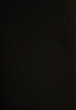 Svart tyg med en texturerad yta som har vertikala linjer och visar en mjuk, vävd karaktär. Idealisk för plagg eller tillbehör.