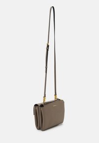 Brown leather crossbody bag with adjustable strap, double zippered compartments, gold hardware accents, and textured finish.
